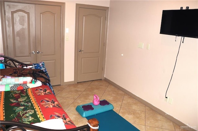 bedroom with light tile patterned floors and baseboards