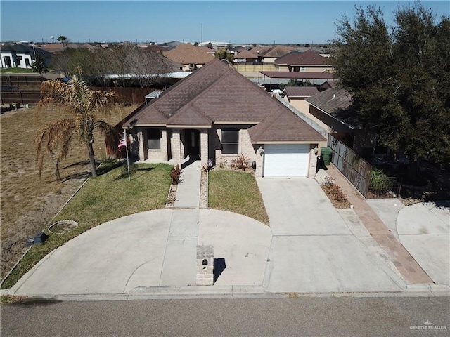 view of front of house featuring concrete driveway, a residential view, an attached garage, fence, and a front yard