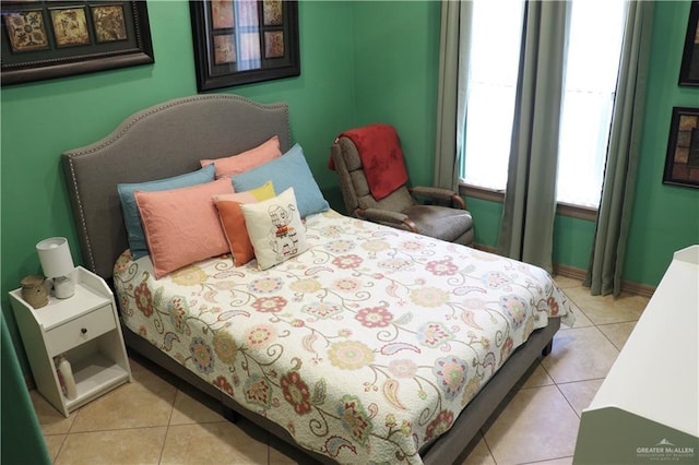 bedroom with baseboards and light tile patterned floors