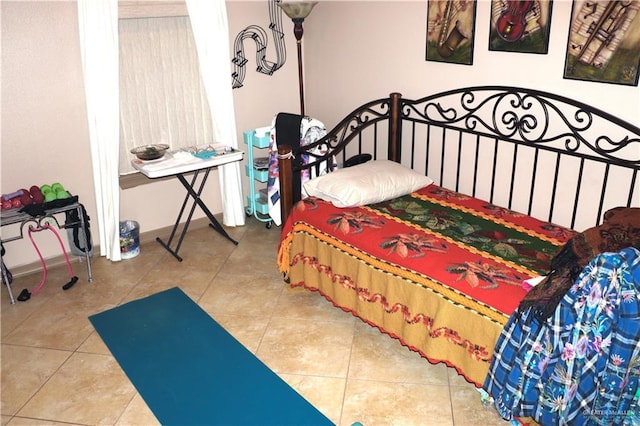 tiled bedroom featuring baseboards