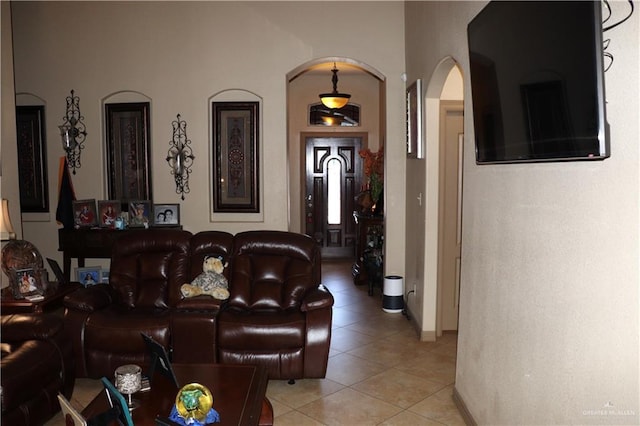 living room with light tile patterned floors and arched walkways