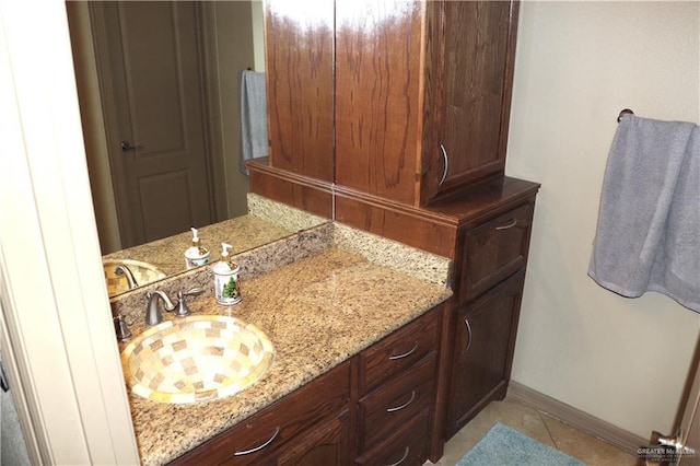 bathroom with vanity, baseboards, and tile patterned floors