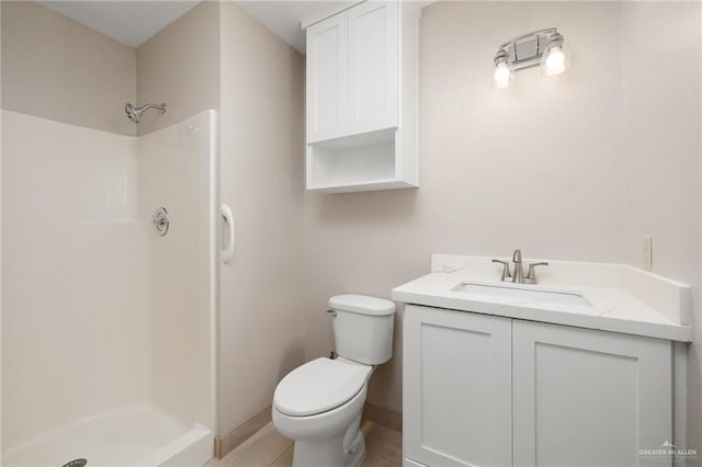 bathroom featuring tile patterned floors, toilet, vanity, and walk in shower