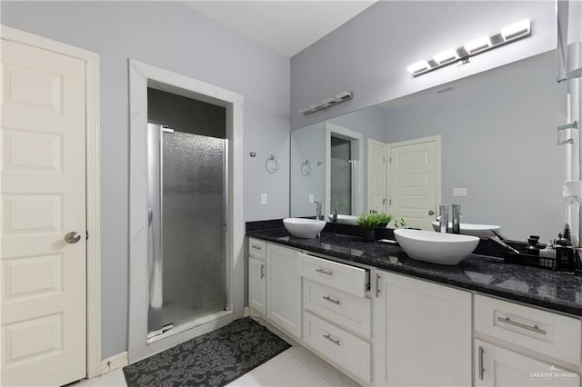 bathroom featuring tile patterned flooring, vanity, and a shower with shower door