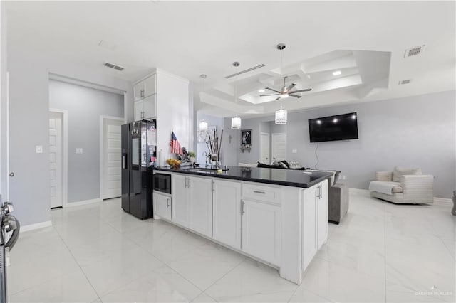 kitchen with stainless steel appliances, a tray ceiling, ceiling fan, decorative light fixtures, and white cabinets