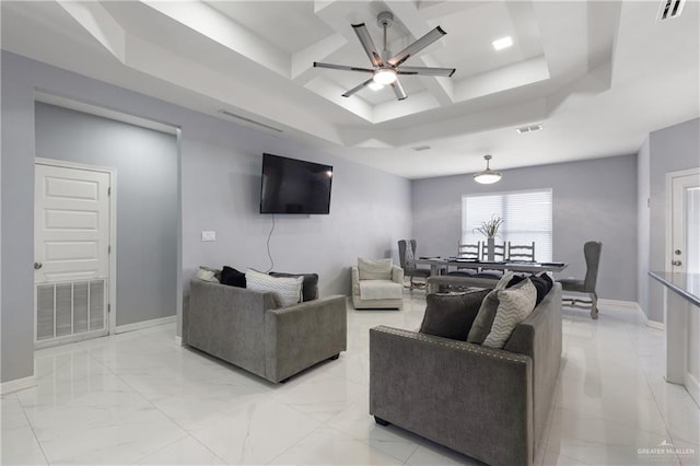 living room featuring a raised ceiling and ceiling fan