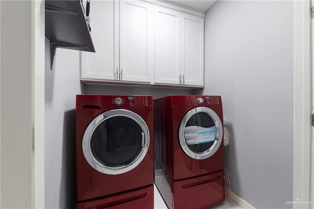 clothes washing area featuring light tile patterned flooring, cabinets, and independent washer and dryer