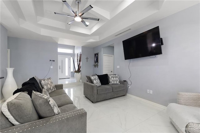 living room with ceiling fan and a raised ceiling