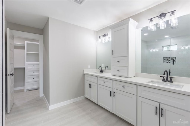 bathroom featuring a tile shower and vanity