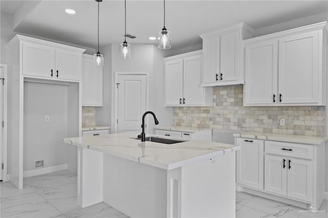 kitchen featuring a kitchen island with sink, recessed lighting, a sink, marble finish floor, and decorative light fixtures