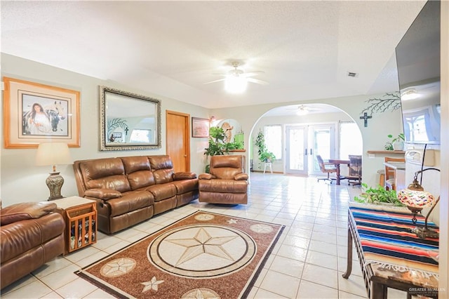 tiled living room featuring french doors and ceiling fan