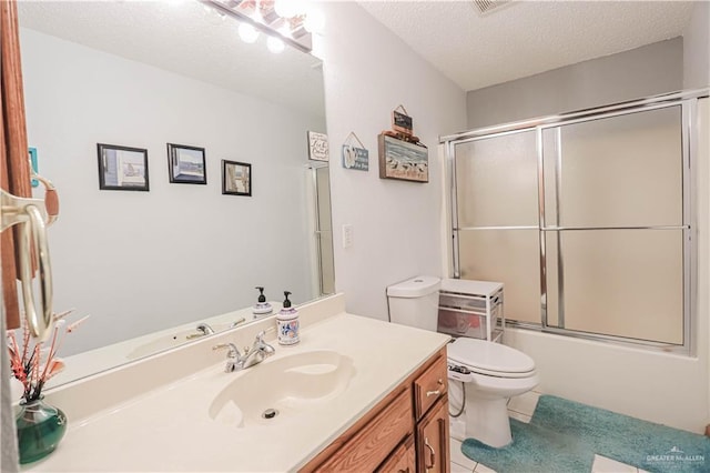 full bathroom featuring bath / shower combo with glass door, toilet, tile patterned floors, a textured ceiling, and vanity