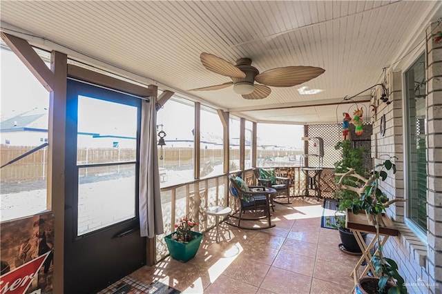 sunroom / solarium featuring a ceiling fan