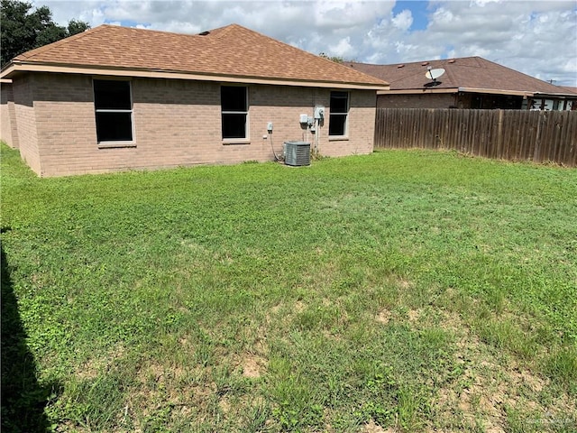 back of house featuring central AC and a lawn