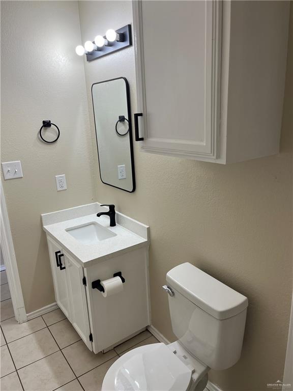 bathroom featuring tile patterned flooring, vanity, and toilet