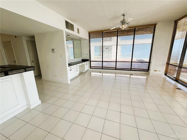 unfurnished living room with expansive windows, light tile patterned flooring, and ceiling fan