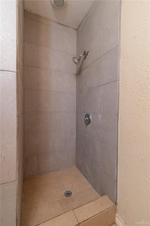 bathroom featuring tiled shower and a textured ceiling