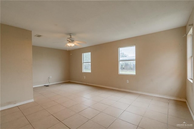 tiled spare room featuring ceiling fan