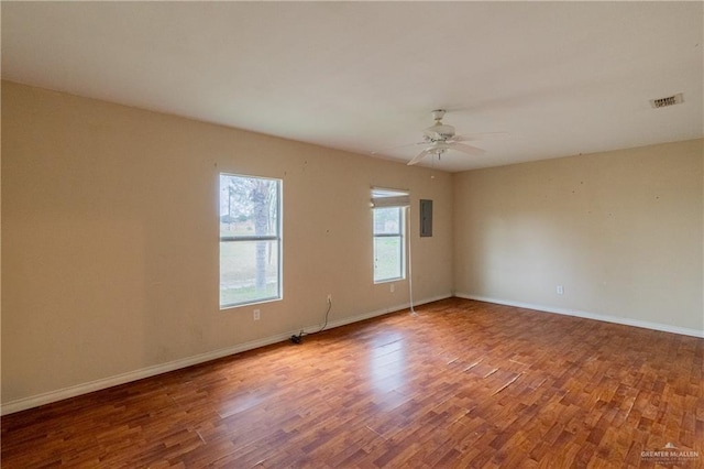 spare room featuring hardwood / wood-style flooring, ceiling fan, and electric panel