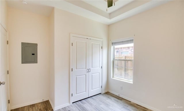 unfurnished bedroom featuring electric panel, light hardwood / wood-style flooring, and a closet