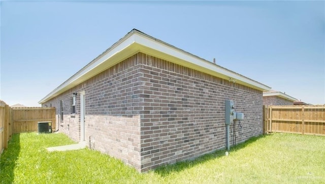 view of home's exterior with a lawn and central AC