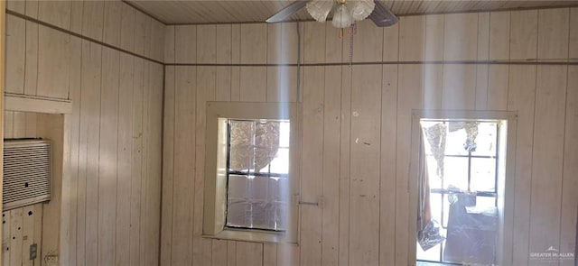 interior space with ceiling fan and wood walls