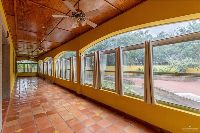 unfurnished sunroom featuring ceiling fan and wood ceiling