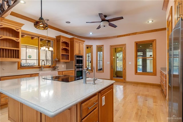 kitchen with decorative light fixtures, plenty of natural light, a kitchen island with sink, and stainless steel appliances