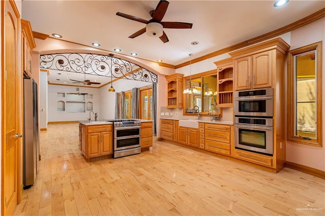 kitchen featuring decorative light fixtures, light hardwood / wood-style floors, sink, and appliances with stainless steel finishes