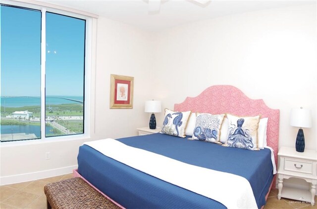 310A Padre Blvd Unit 1305, South Padre Island, TX 78597 - tiled bedroom with baseboards, a ceiling fan, and a water view