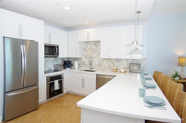 310A Padre Blvd Unit 1305, South Padre Island, TX 78597 - kitchen with appliances with stainless steel finishes, a peninsula, a sink, decorative backsplash, and light countertops