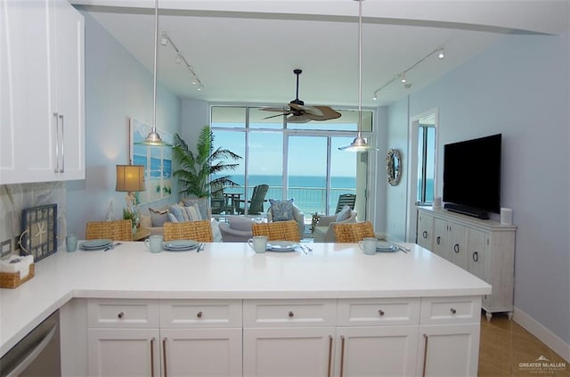 310A Padre Blvd Unit 1305, South Padre Island, TX 78597 - kitchen with rail lighting, a peninsula, ceiling fan, white cabinets, and light countertops
