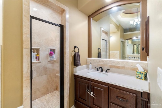 bathroom featuring crown molding, a shower with door, vanity, and a chandelier