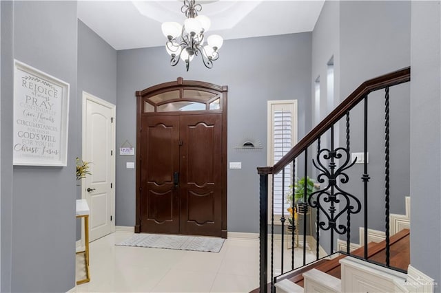 tiled entrance foyer featuring a chandelier