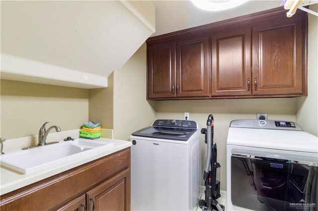 laundry room with cabinets, washer and dryer, and sink