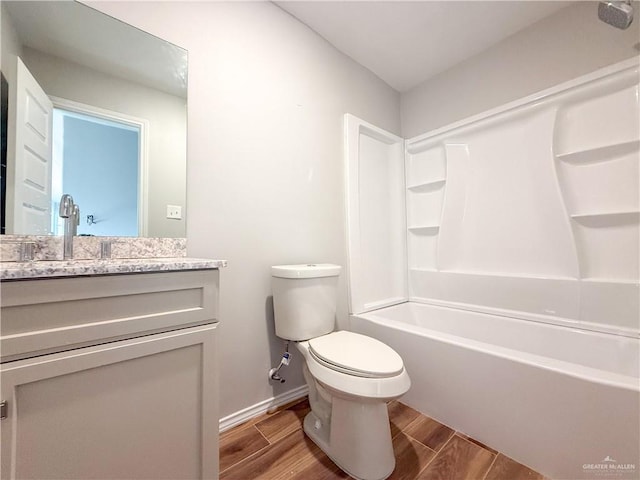 full bathroom featuring bathing tub / shower combination, hardwood / wood-style floors, vanity, and toilet