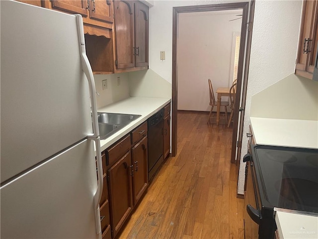 kitchen featuring stove, sink, light hardwood / wood-style flooring, dishwasher, and white fridge