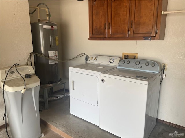 clothes washing area featuring water heater, cabinets, and washer and dryer