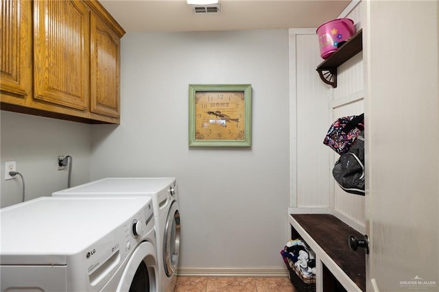 washroom with washer and clothes dryer, light tile patterned floors, visible vents, cabinet space, and baseboards