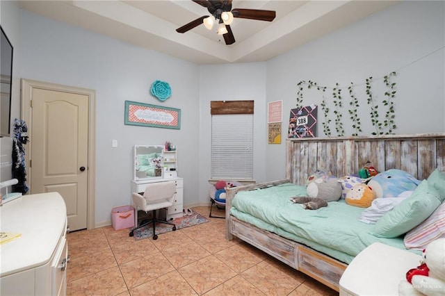 bedroom featuring a raised ceiling, ceiling fan, and light tile patterned floors