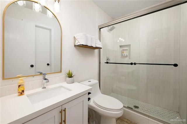 full bathroom featuring a shower stall, vanity, and toilet