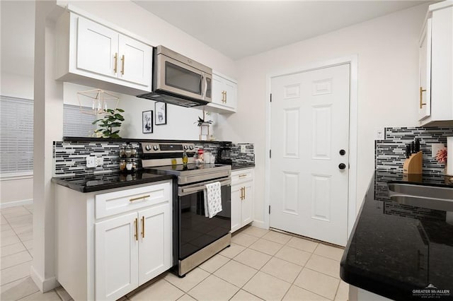 kitchen featuring white cabinetry, appliances with stainless steel finishes, backsplash, and light tile patterned flooring