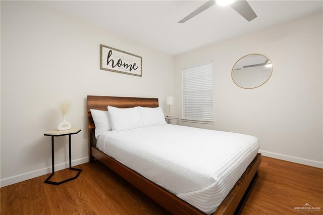 bedroom with ceiling fan, baseboards, and wood finished floors