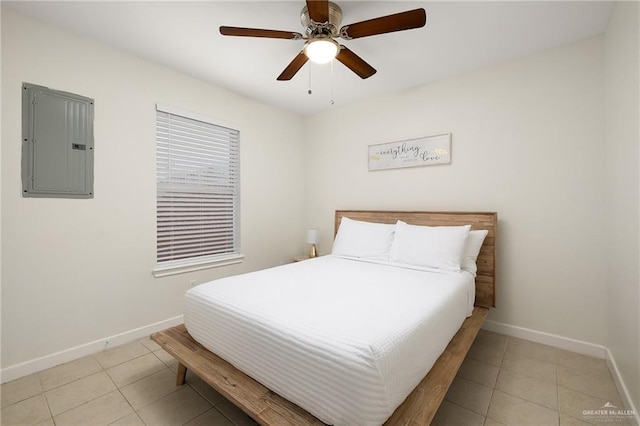 bedroom with light tile patterned floors, electric panel, baseboards, and a ceiling fan