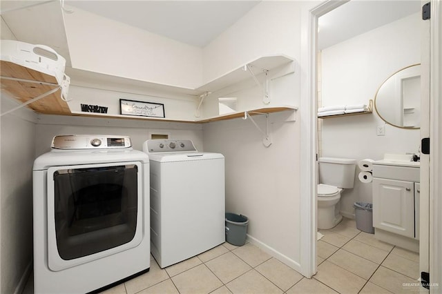 laundry room featuring light tile patterned flooring, washing machine and dryer, laundry area, a sink, and baseboards