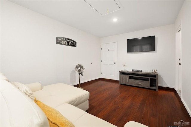 living area with dark wood-type flooring, attic access, and baseboards