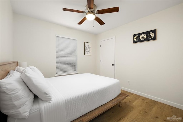 bedroom with ceiling fan, baseboards, and wood finished floors