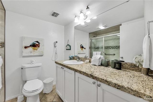 bathroom with tile patterned floors, vanity, toilet, and walk in shower