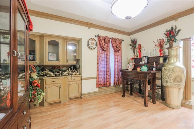 dining space with light wood-style floors and ornamental molding