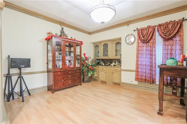 interior space with baseboards, crown molding, and light wood-style floors